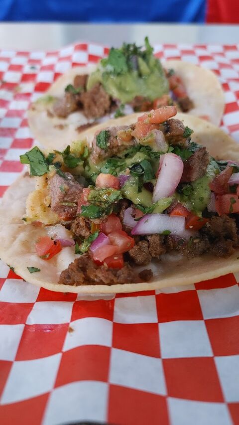 Three street tacos on soft corn tortillas with carne asada, guacamole, diced tomato, red onion and fresh cilantro.